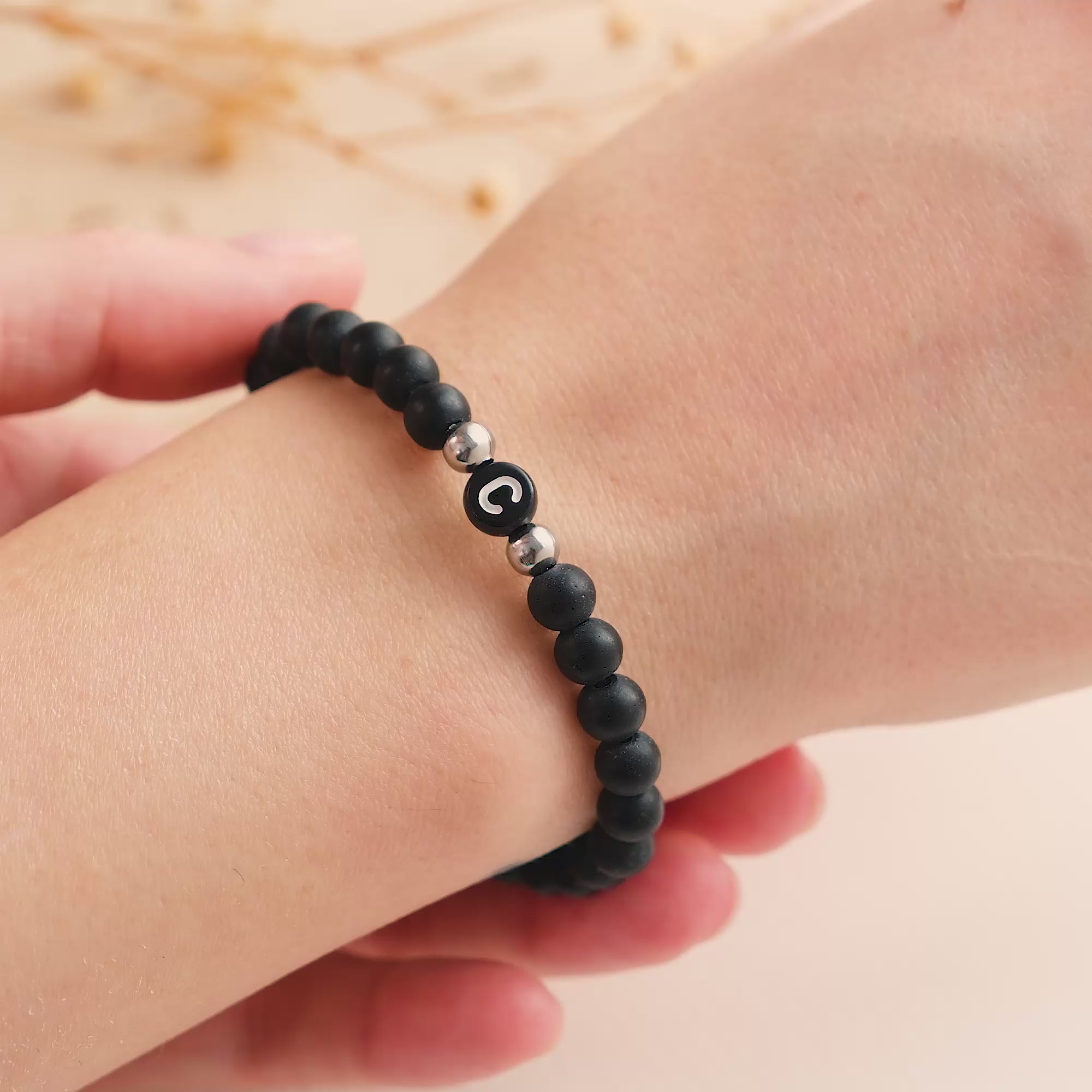 Braccialetto iniziale con perle nere